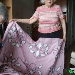 Dolly shows her quilt top that she will hand quilt.
